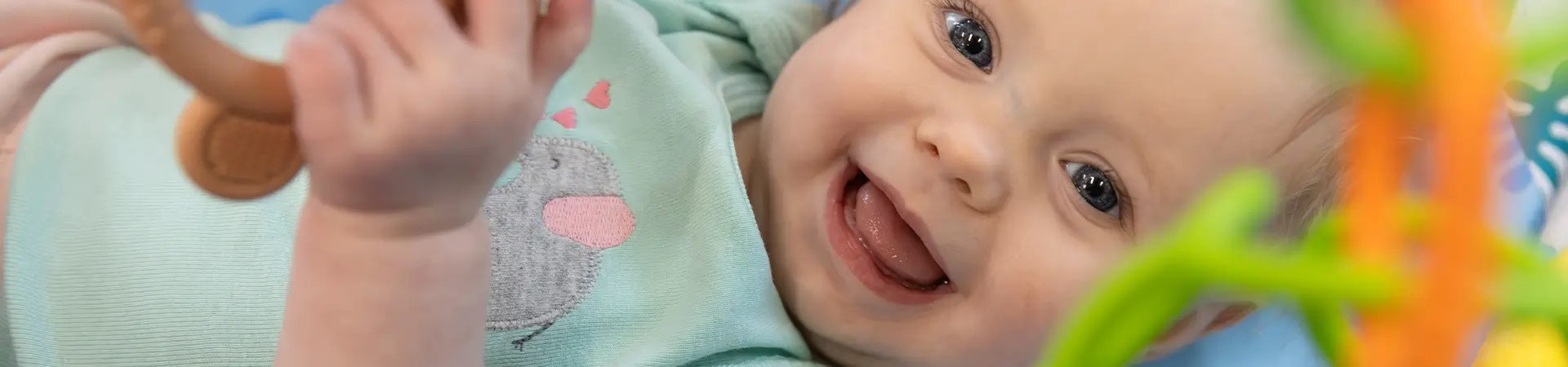 Closeup Face Of Smiley Baby Laying On Mat