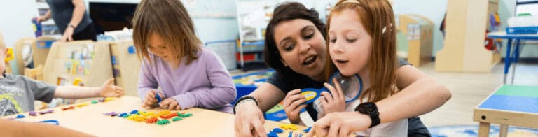 a teacher helping a child identify colorful plastic bugs